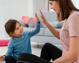 A child giving a high five to a behaviour consultant